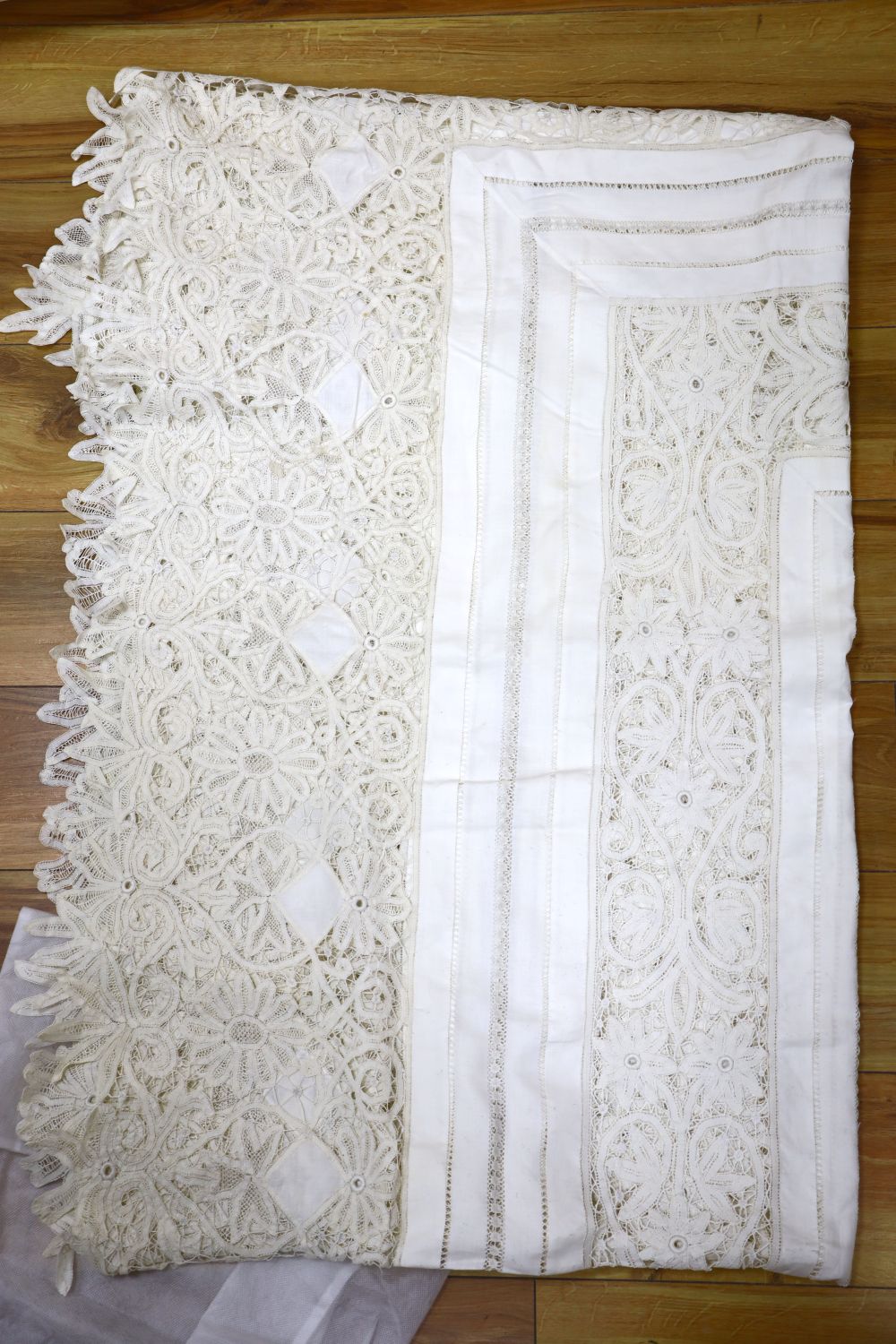 An ornate tape lace edged bed cover with drawn threadwork linen panels to fit a single bed, 94cm